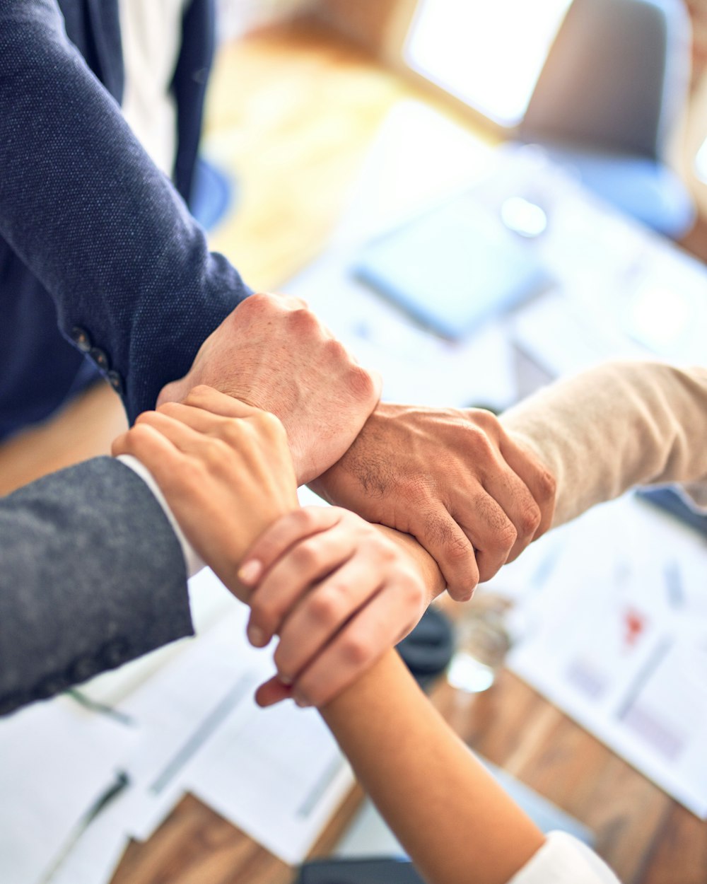 Business partners joining hands across a table